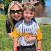 Mom hugging child in baseball uniform